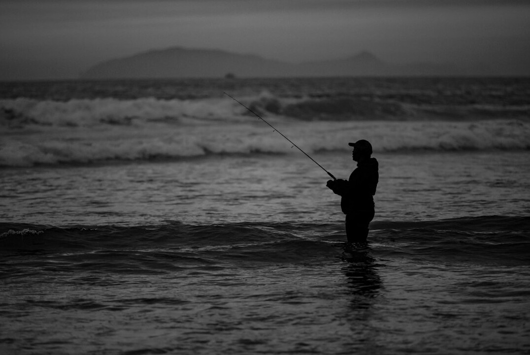 fisherman at sea black white