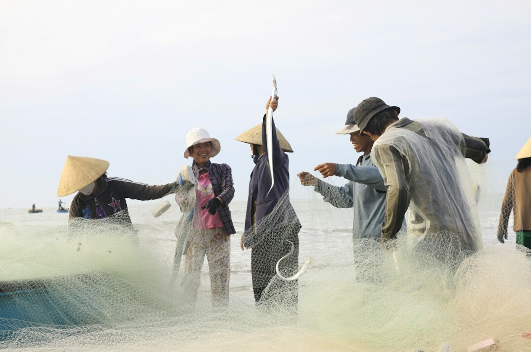 women repairing fishing nets